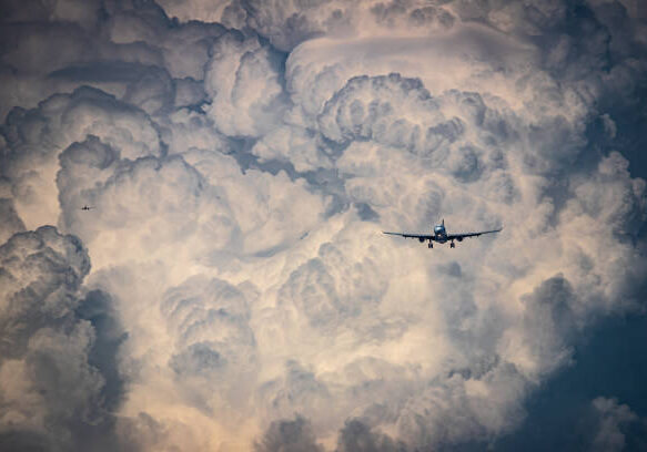 Two airplanes approaching for landing with beatiful stormy clouds background